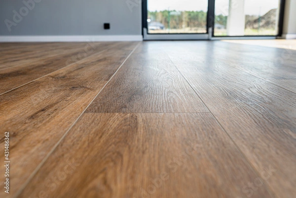 Obraz Modern vinyl panels imitating wood in the living room with selective focus and a shadow falling from the window.