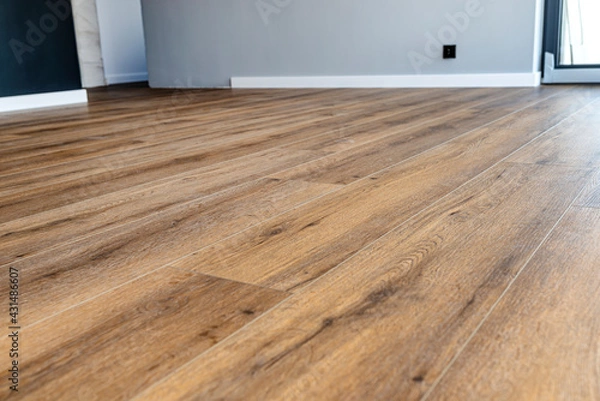 Obraz Modern vinyl panels imitating wood in the living room with selective focus and a shadow falling from the window.