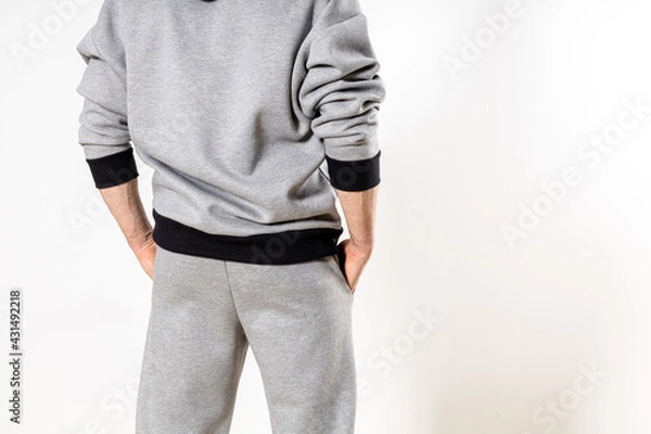 Fototapeta man in a gray tracksuit on a white background, copy space