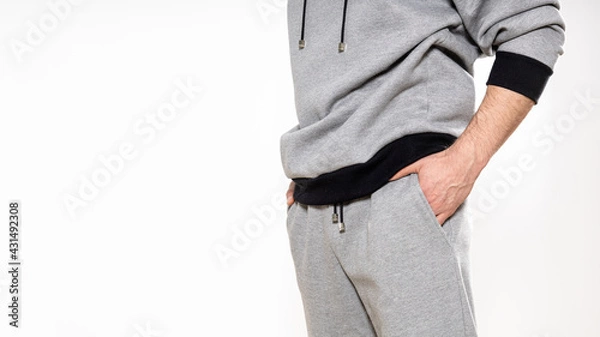 Obraz man in a gray tracksuit on a white background, copy space