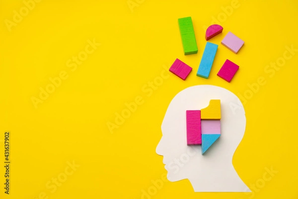 Fototapeta Papercut head silhouette with toy constructor pieces on yellow background