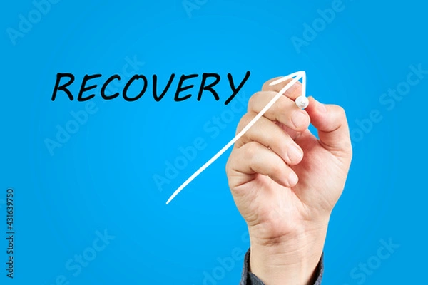 Fototapeta Hand of man drawing an arrow going up next to the word Recovery