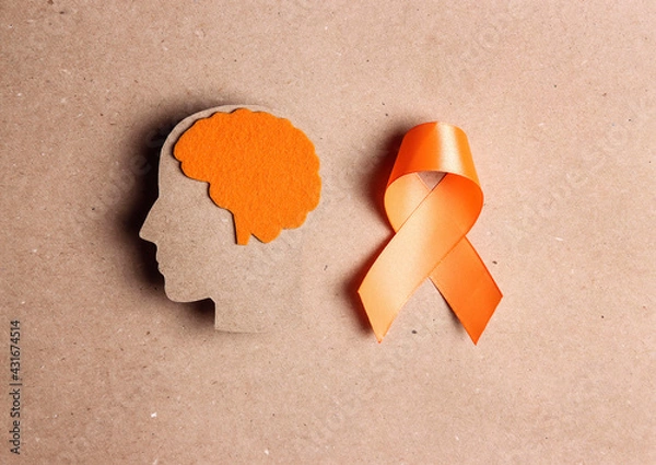 Obraz  Orange awareness ribbon and brain symbol on a brown background.
