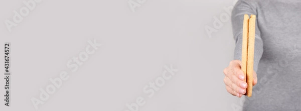 Fototapeta Hand with cookie stick on grey background.