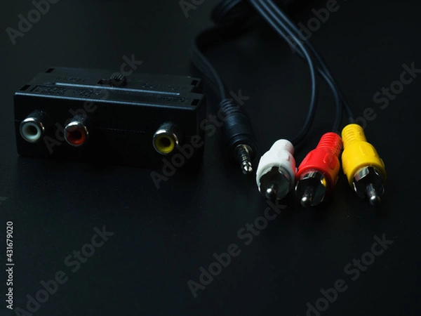 Obraz Audio-video adapter with plugs on dark background.