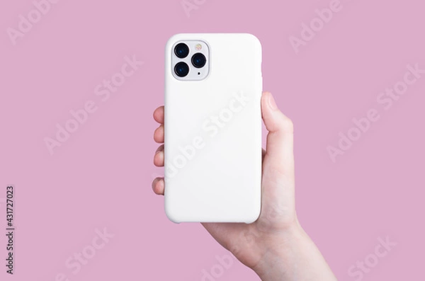 Obraz Female hand holding white iPhone 11 Pro in soft silicone white cover back view . Phone case mock up isolated on pink background , iPhone 12