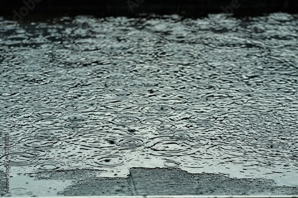Obraz Rain is makes circles on a black flat roof