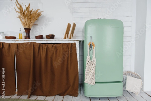 Fototapeta part of the kitchen interior with a table and an old green vintage refrigerator