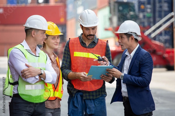 Fototapeta Foreman and secretary clipboard   meeting with worker to checking  control loading Containers box at warehouse logistic in Cargo freight ship for import export in harbor. shipping in docks.