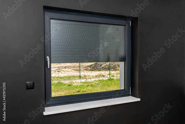 Obraz A large window in a room with black walls, half covered with external blinds.