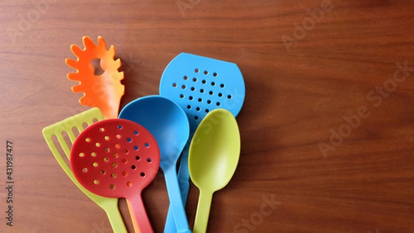 Obraz A variety of colorful kitchen utensils on a wooden surface.