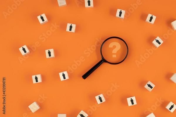 Fototapeta Search for highly qualified employees or talent using a magnifying glass with a question mark on an orange background.