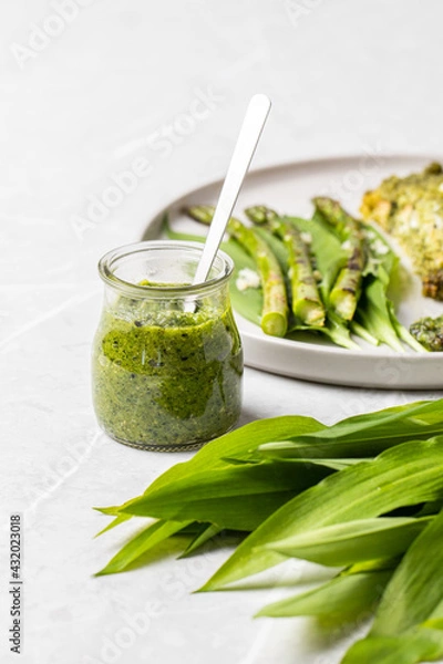 Fototapeta Wild garlic pesto. Green asparagus with salmon. Salmon fillet with green pesto. Wild garlic pesto in a glass
