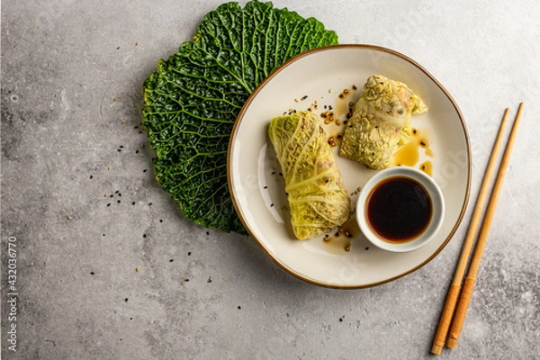 Fototapeta Leaves of Savoy cabbage stuffed with vegetables. Asian cabbage rolls. Vegan. Top view.