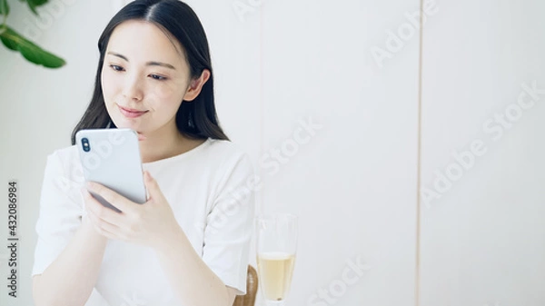 Fototapeta 笑顔でスマホを見る女性