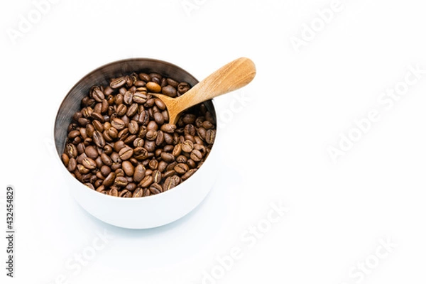 Obraz Mixture of different kinds of roasted coffee beans with wooden spoon in white container on white background. Copy space.