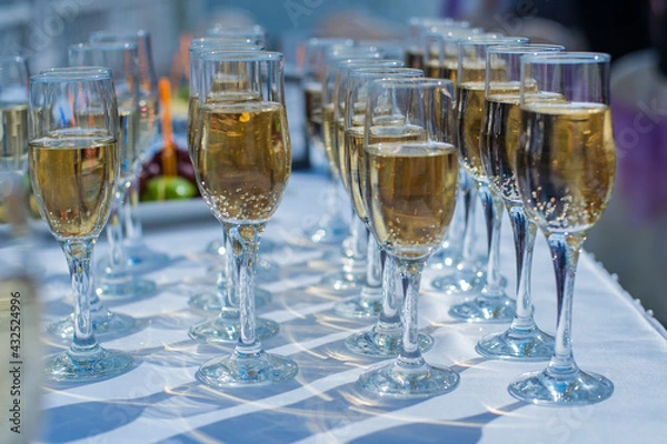Obraz Glasses of champagne on the table, beautiful shadow on the white surface.