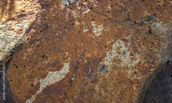 Fototapeta Brown andesite stone surface texture. Brown-grey rock with  cracks and cavities. Template for background