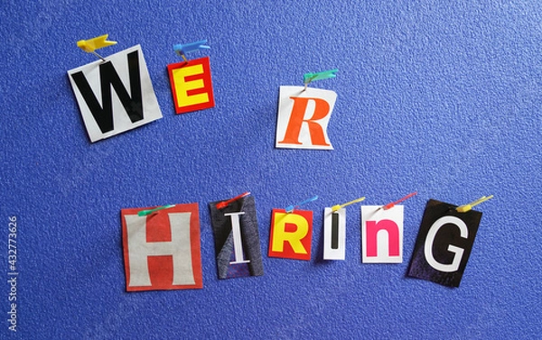 Fototapeta We are hiring, colorful letters cut out from magazine, pin out on board