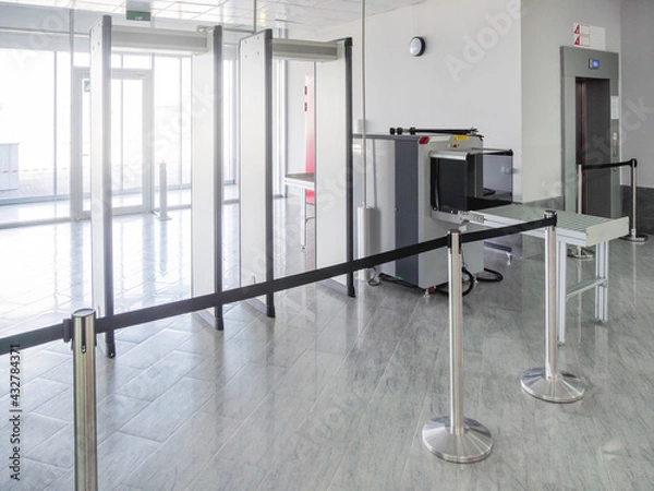 Obraz Metal detector frame and X-ray machine for checking luggage and hand baggage at entrance to public building. Checkpoint with security and anti-terrorist measures.