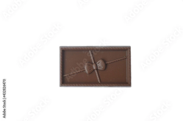 Fototapeta Bar of chocolate with a bow on a white background. Isolate.
