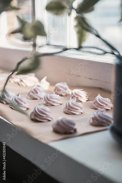 Fototapeta Homemade marshmallow on parchment paper dries in the sun on a windowsill. Homemade sweets, comfort, handmade