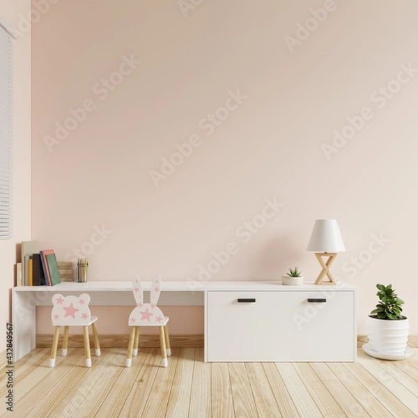 Obraz Children's room with cream colored walls is blank. There were books, colored pencils and lamps on the table and a chair and a tree on the floor.3d rendering.