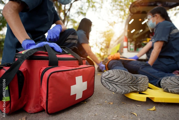 Fototapeta Emergency Medical First aid kit bags of first aid team service for an accident in work of worker loss of function in limbs, First aid training to transfer patient