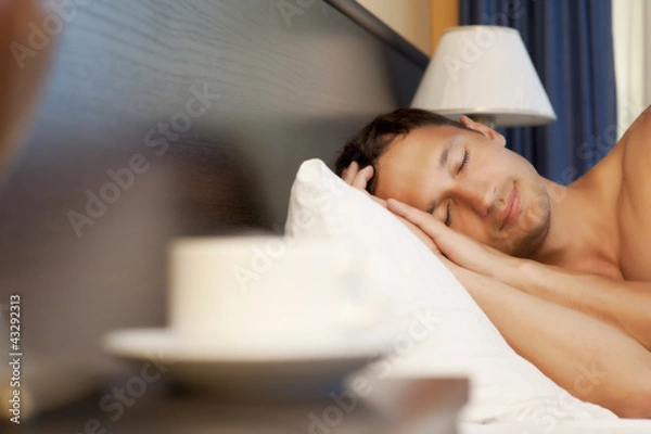 Obraz man sleeping on a bed. morning tea