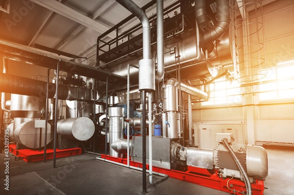 Fototapeta Rankine organic cycle turbine (ORC-turbine) installed in modern industrial boiler room with control cabinets, equiped for heating process with sun flares.