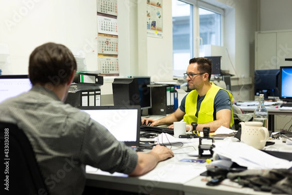 Fototapeta Büroarbeit - Mehrere Mitarbeiter arbeiten am Schreibtisch vor ihren PC's