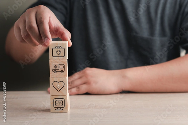 Fototapeta Health and life insurance concept for emergency medical treatment, with medical icons on wooden blocks