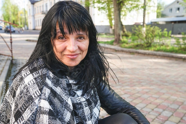 Fototapeta portrait of a woman. Happy smiling Caucasian woman with black medium hair. Copy space concept. Skin problems. Ageing and wrinkles. Getting old. Happy retirement.
