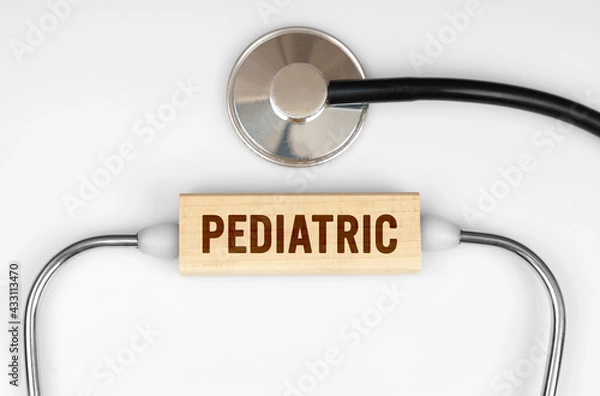 Fototapeta On the table is a stethoscope and a wooden plate with the inscription - PEDIATRIC