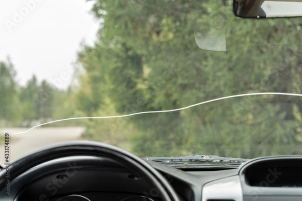 Fototapeta A large crack on the windshield of a vehicle in which vehicle operation is prohibited. A crack in all the glass in front of the driver and in front of the passenger.