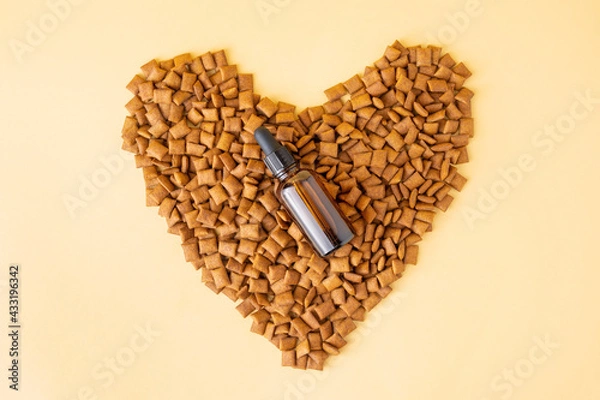 Fototapeta Mineral and vitamin tincture or homeopathic medical treatment for cats and dogs in brown vial with pipette. Natural supplements for pets. Mockup of bottle on heart-shaped pet's food. Flat lay