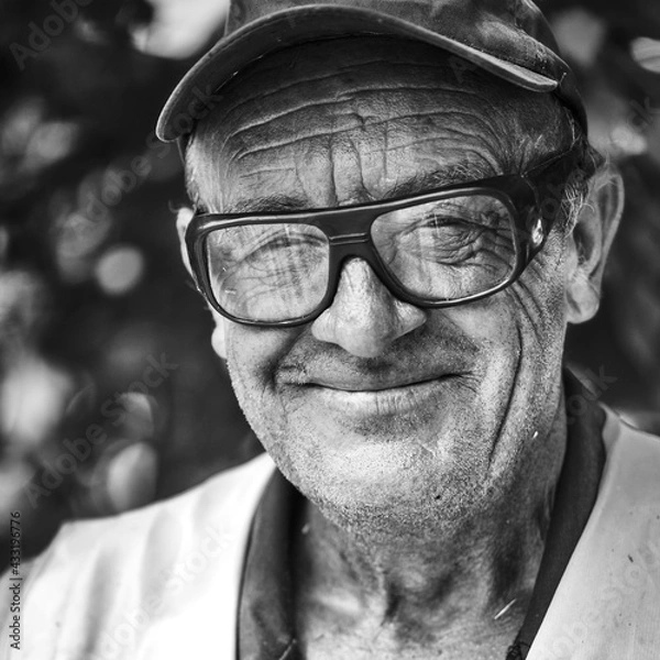 Fototapeta Portrait of smiling old man with wrinkled face. Black and white portrait .