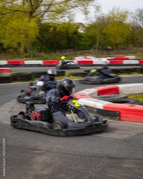 Fototapeta A panning shot of a racing kart as it circuits a track.