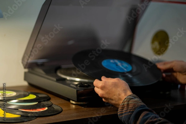 Obraz hands put a vinyl record on a turntable