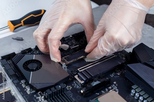 Fototapeta Technician is installing new fast high capacity SSD drive
