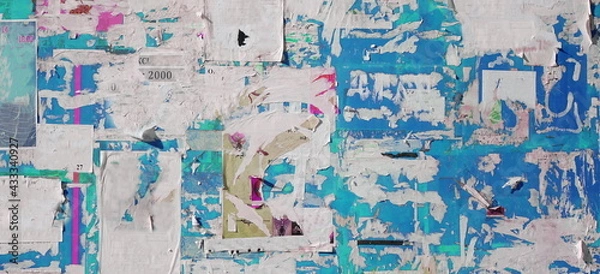 Fototapeta Artistic Urban Street Background with Grungy Wall with Ripped, Torn And Peeled Posters. Old Wall with Scratched Advertising. Old Billboard with Torn Posters. Vintage Wide Background and Texture.