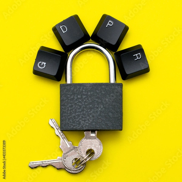 Obraz closed iron padlock with keys on a yellow background on the lock lever the keys of the computer keyboard are lined with the abbreviation GDPR the concept of personal data protection