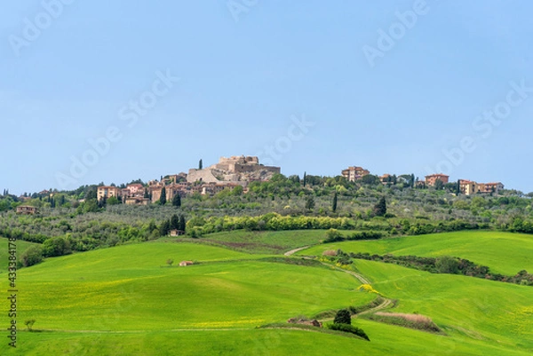 Fototapeta Amazing spring view of medieval small town with cypress trees and colorful spring flowers in Tuscany, Italy. Typical Tuscany scenic landscape.