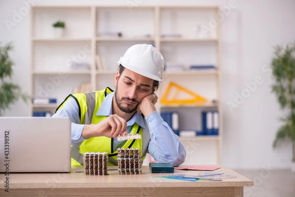 Fototapeta Young male architect suffering at workplace