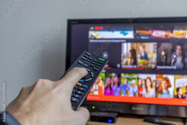 Obraz Ligando televisão com controle remoto.
