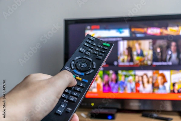 Fototapeta Ligando televisão com controle remoto.