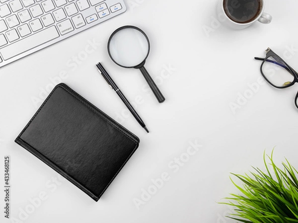 Fototapeta office workplace. Top view of a white table with a white keyboard, glasses, notepad and a cup of black coffee. Morning at the office. Copy space for your text.