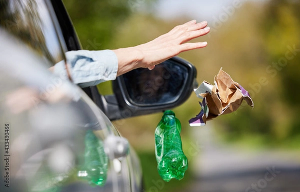 Obraz Close Up Of Driver In Car Dropping Trash Out Of Window On Country Road