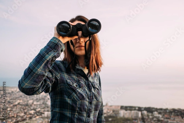 Obraz Woman considering natural landscape with binoculars.