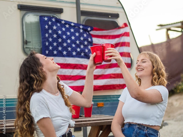 Fototapeta Dos mujeres guapas y jóvenes disfrutando de Día de la Independencia de los Estados Unidos